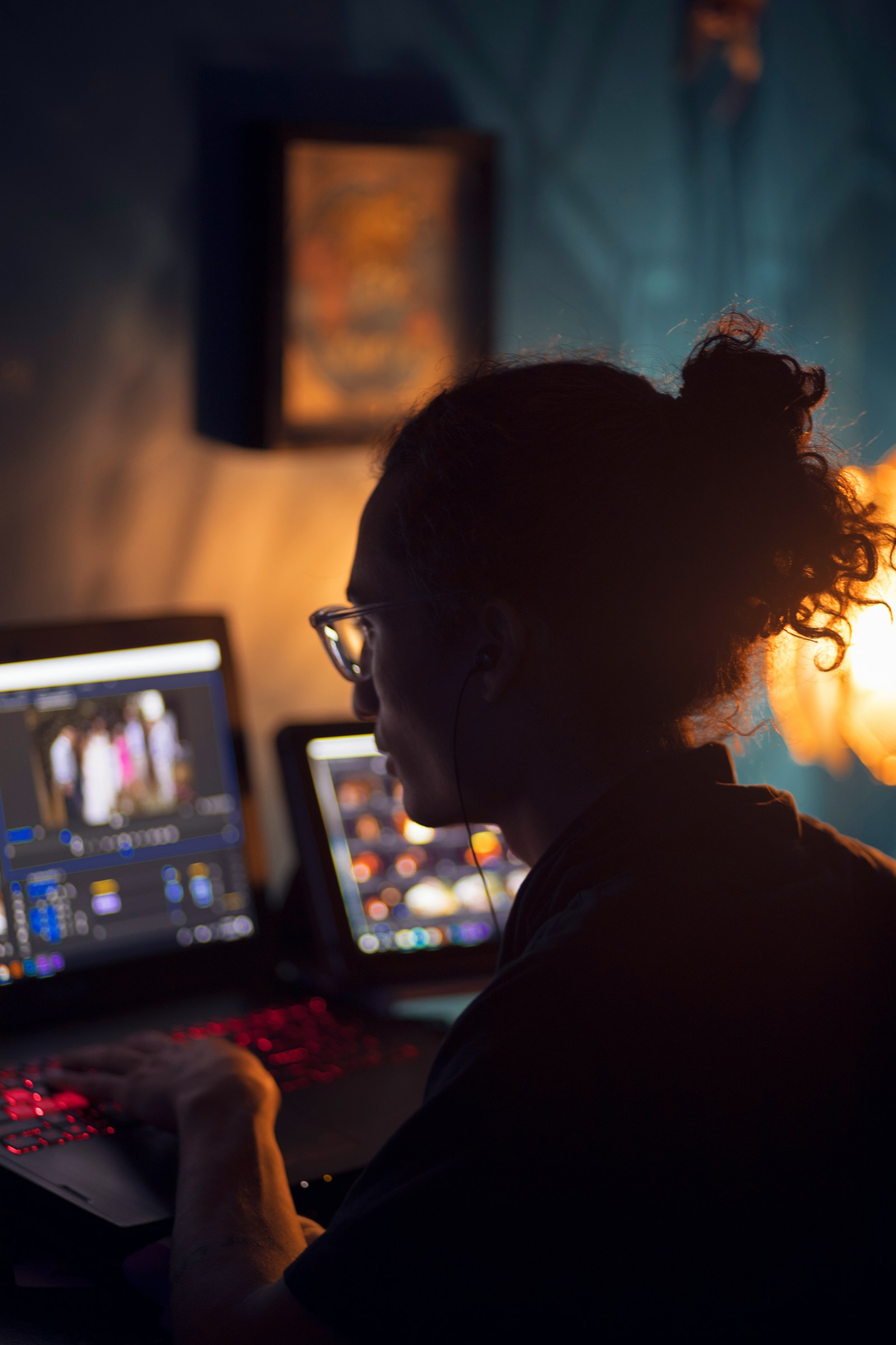 Someone working late on a laptop, reviewing recorded video in a dimly lit home office
